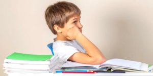 garçon déconcentré qui fait ses devoirs