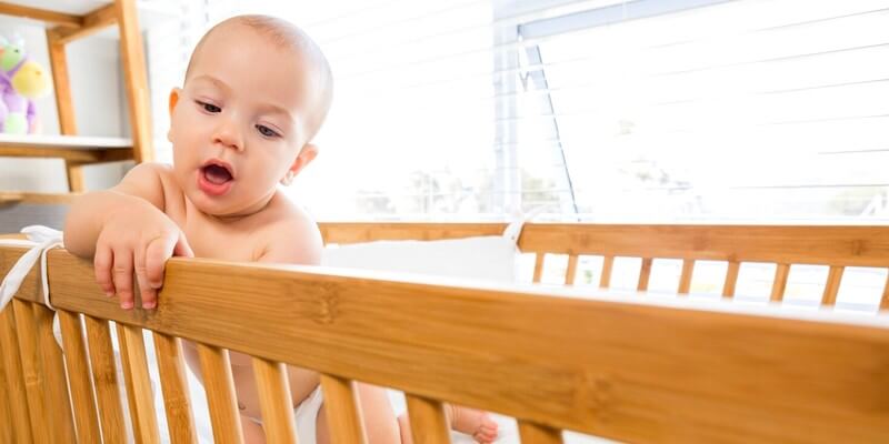 Bébé garçon jouant sur un berceau