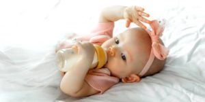bebe-boit-lait-bouteille-lit-blanc