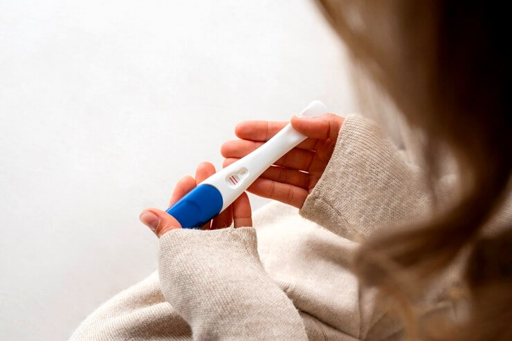 femme tenant un test de grossesse