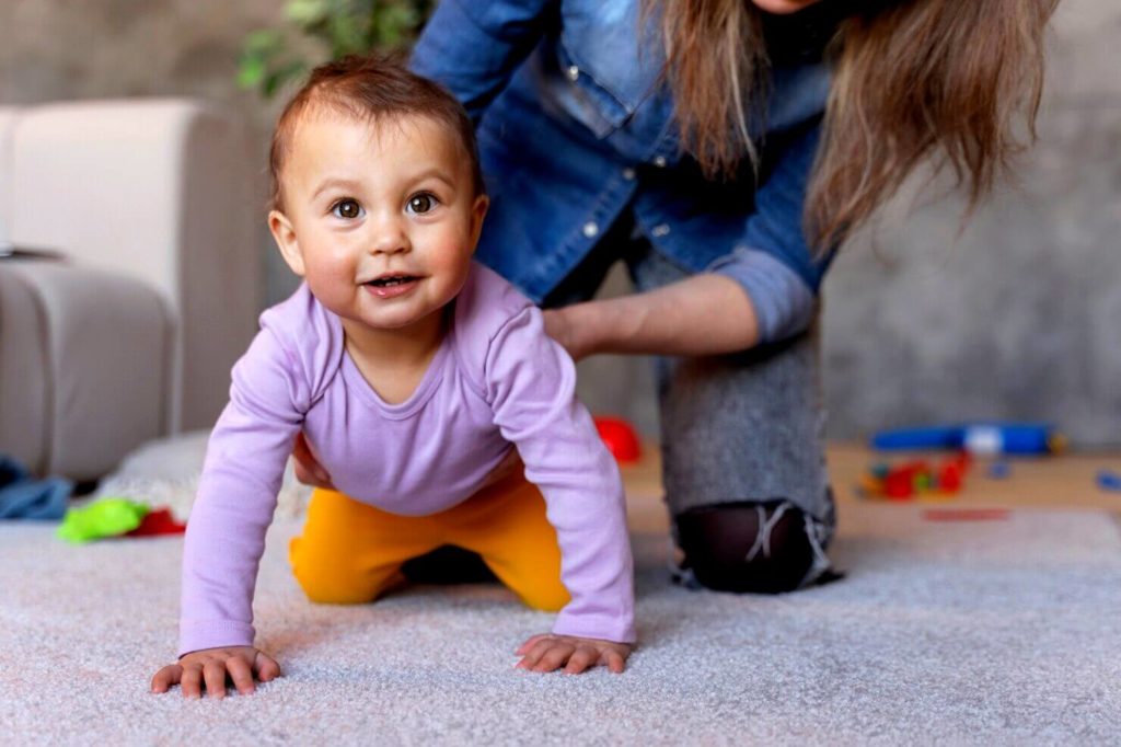 Adorable bébé rampant sur un tapis
