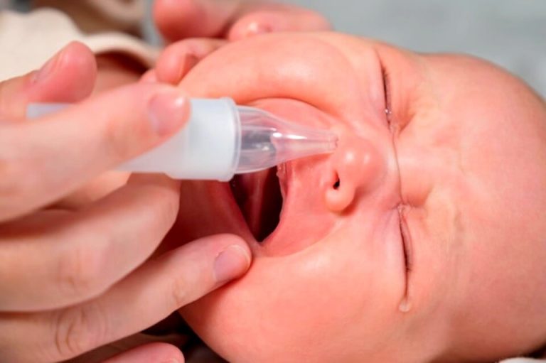 Maman applique une solution saline dans la narine d'un nouveau-né