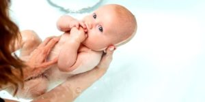Maman lave son bébé dans une baignoire