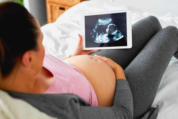 Femme enceinte regardant une échographie de son bébé