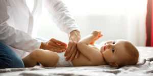 Jeune maman change les couche du bébé