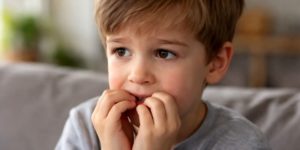 Petit garçon qui se mordille ses ongles